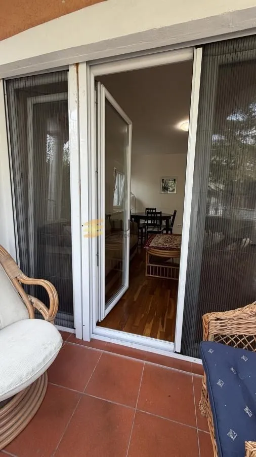 View from the tiled terrace with outdoor seating toward the interior of the apartment.