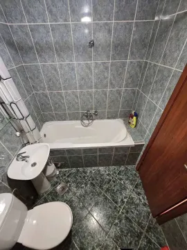 Kupatilo opremljeno kadom, umivaonikom i toaletom sa pločicama u plavim tonovima. - image 7