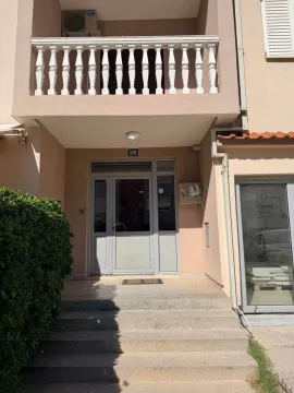 Entrance to a residential building with stairs and a balcony on the upper floor. - image 4