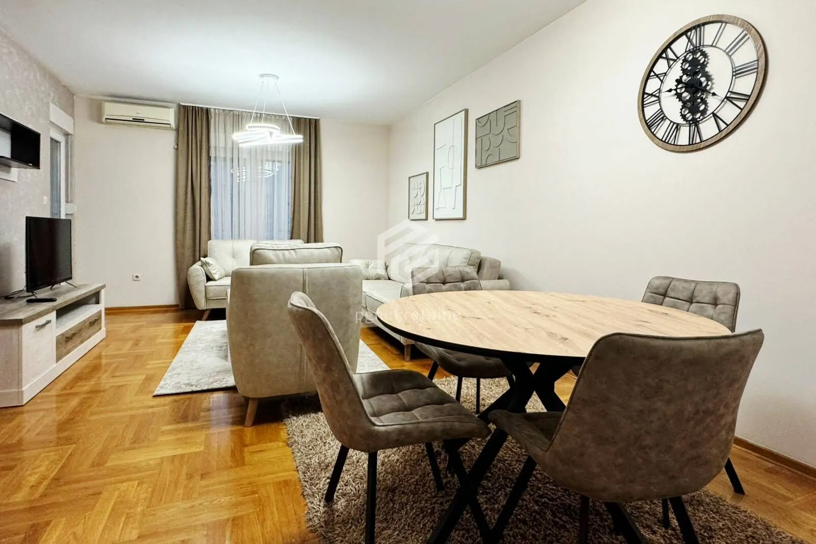 Living room with sofa set, TV unit, and dining table.