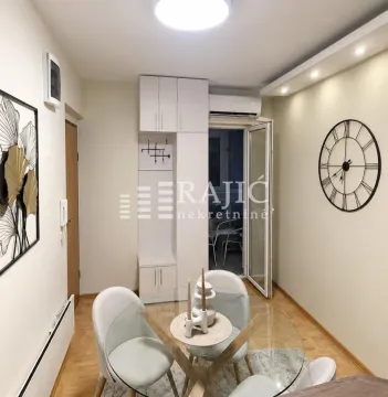 Small dining area with a glass table and modern chairs. - image 2