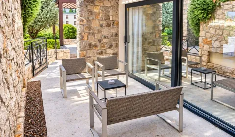 Furnished terrace with seating set and stone walls. - image 21