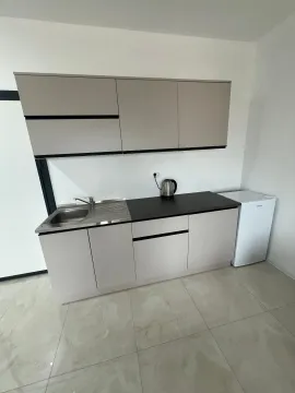 Small kitchen with a sink, cabinetry, and refrigerator. - image 5