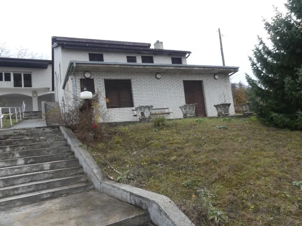 Exterior view of the house with a yard and stairs.