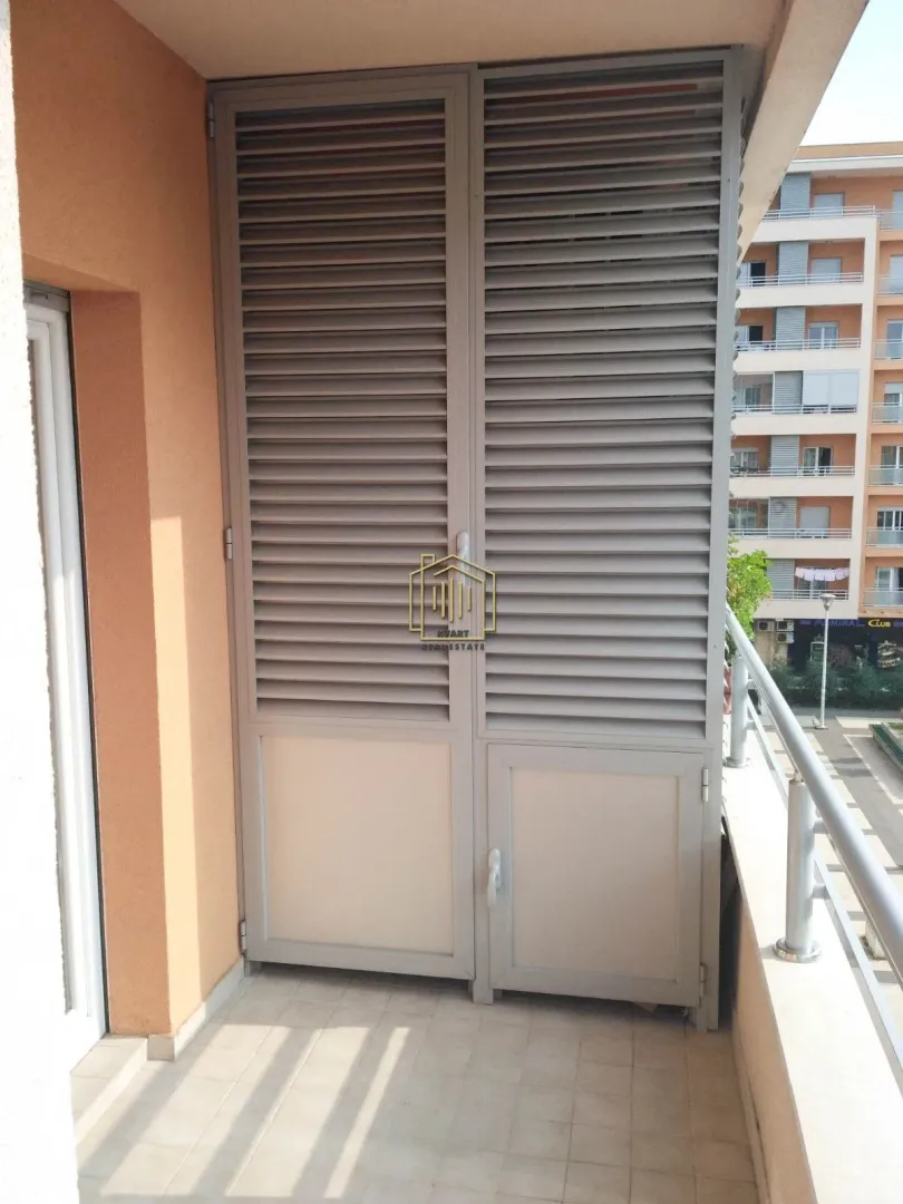 Natkriveni balkon sa ormarićem sa roletnama za odlaganje.