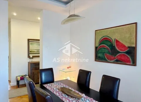 Dining area with a dining table and chairs, decorated with a painting on the wall. - image 8
