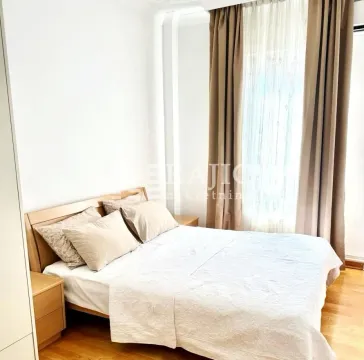 Bright bedroom with a double bed and curtained window. - image 2