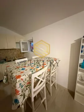 Manja kuhinja sa trpezarijskim stolom prekrivenim cvjetnim stolnjakom. - image 8