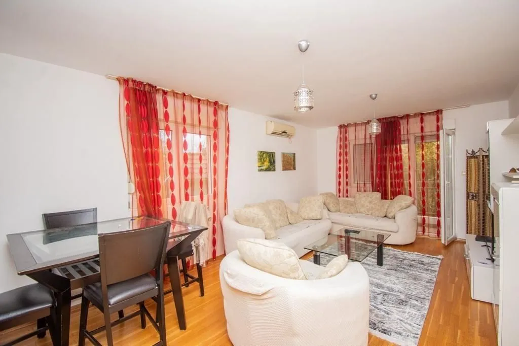 Bright living room with a seating set and a dining table.