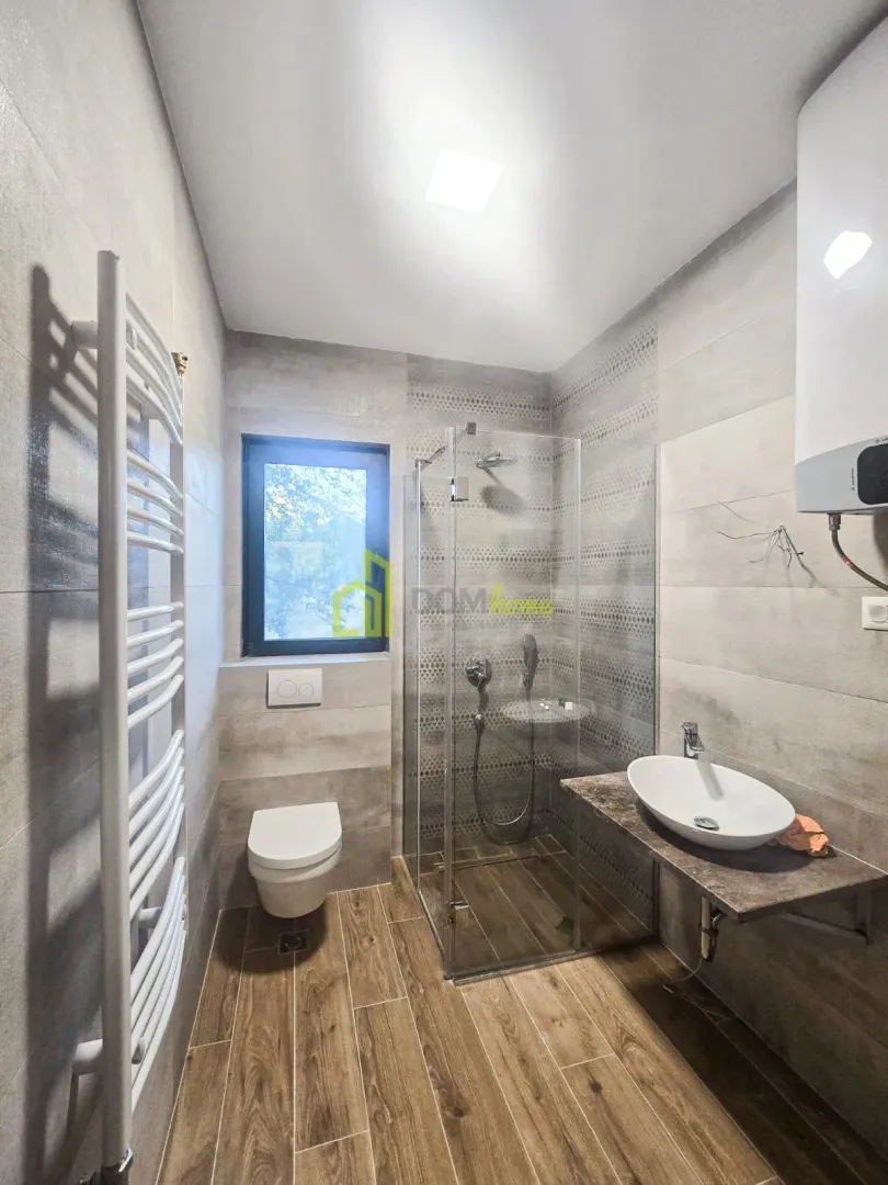 Moderne kupatilo sa tuš kabinom, umivaonikom i wc šoljom.