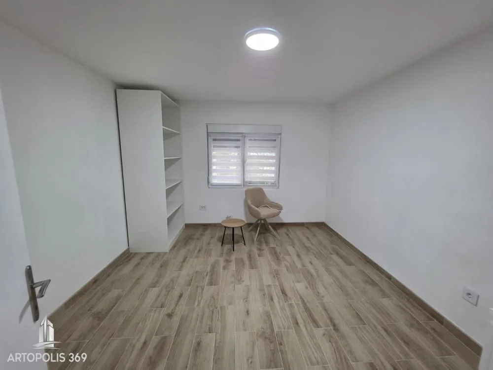 Empty room with white walls, laminate flooring and a wardrobe.