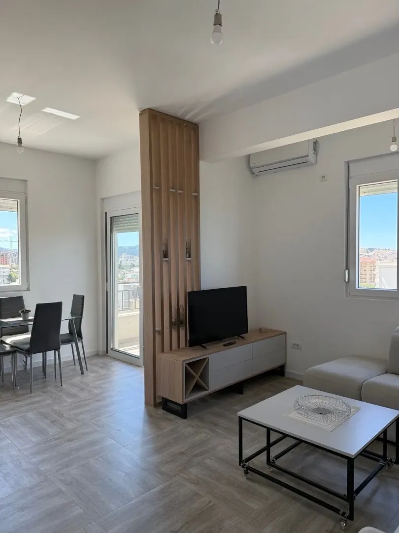 Bright living room with a dining area and a wooden partition wall.