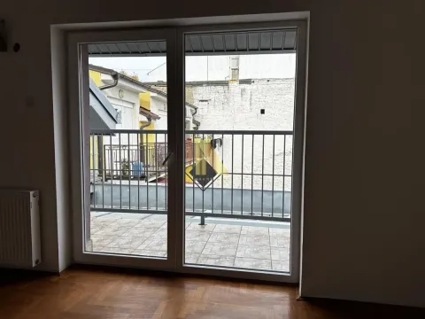 View through the balcony doors to the terrace and neighboring buildings. - image 8