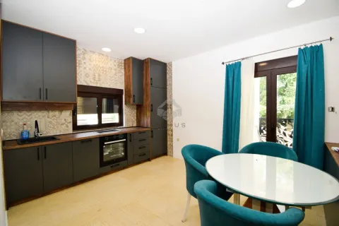 Modern kitchen with dark cabinets and a dining table with blue chairs. - image 11
