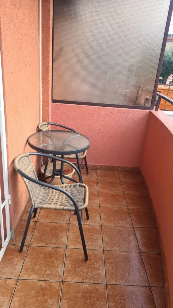 A small terrace with a table and two chairs.