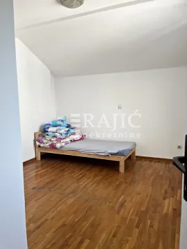 A bedroom with a wooden bed and hardwood flooring. - image 7