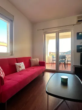 Living room with a red sofa and access to the terrace. - image 4