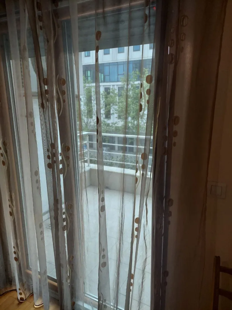 View through the balcony door to the terrace and surrounding buildings.