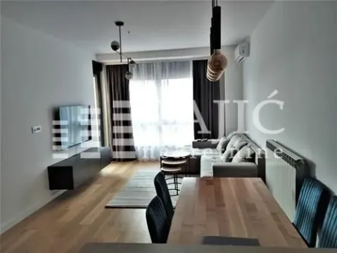 Modern living room with a sofa, TV, and dining table. - image 2