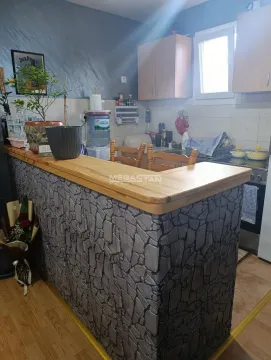 Kitchen with a stone-clad breakfast bar and wooden cabinetry. - image 8