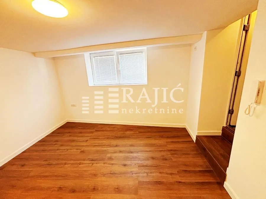 Empty room with laminate flooring and white walls.