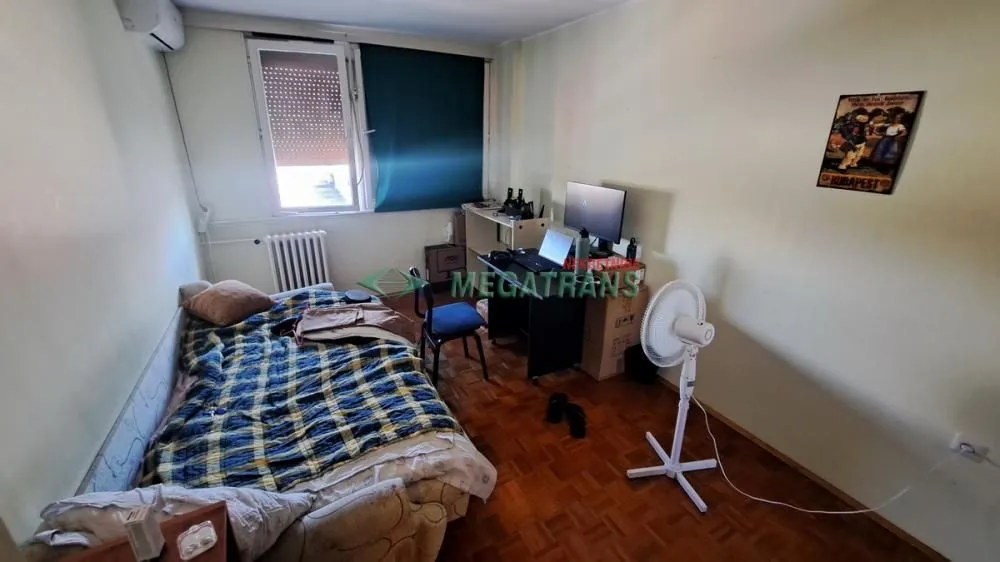 Smaller bedroom with a bed and a desk.