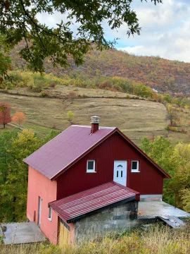 Pogled na kuću sa crvenim krovom u prizemnom okruženju. - image 6