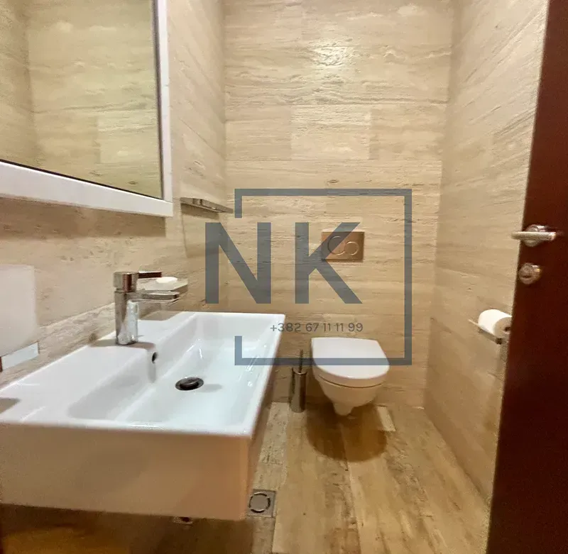 Small tiled bathroom with a washbasin and a toilet.