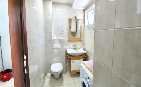 Small bathroom with a washbasin, toilet, mirror, and washing machine. - image 7