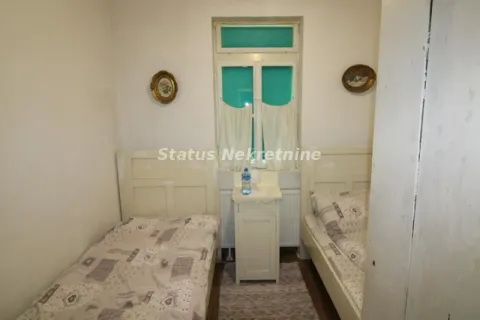 Smaller bedroom with two single beds and a window in the middle. - image 11