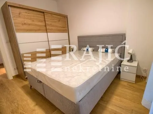 Furnished bedroom with a double bed and a large wardrobe.