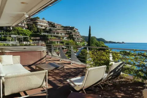 Spacious terrace with seating furniture, a jacuzzi, and a view of the sea and the resort. - image 10