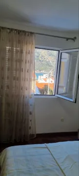 Pogled kroz prozor spavaće sobe na more i okolne objekte. - image 6