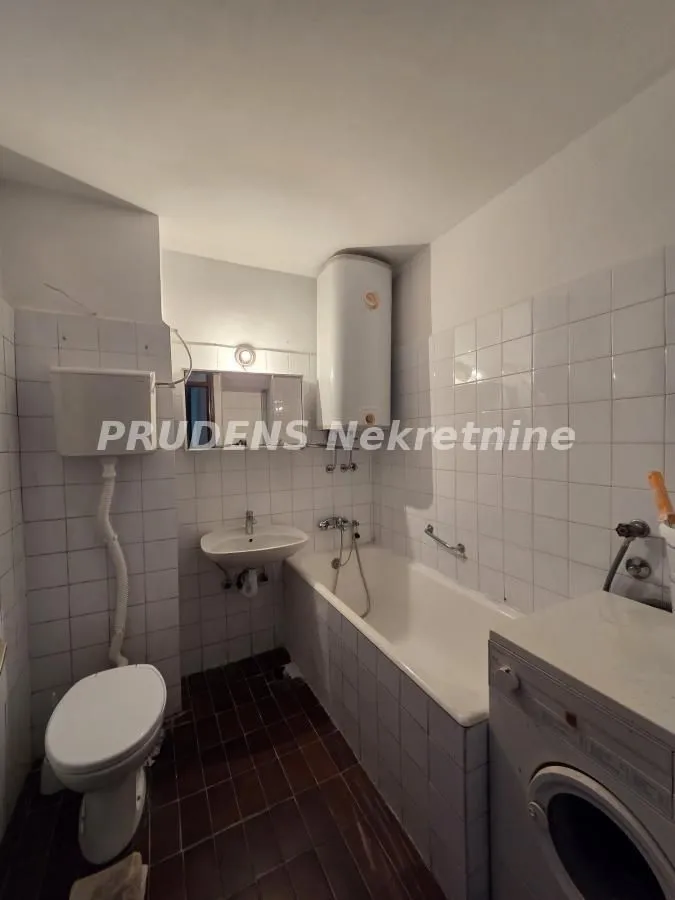 Manje opremljeno kupatilo sa kadom, umivaonikom i wc šoljom.