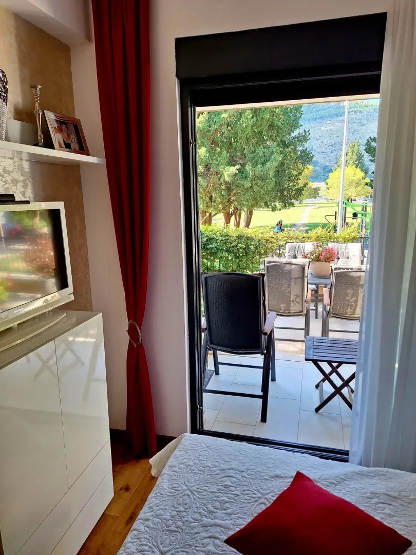 Spavaća soba sa izlazom na terasu i pogledom na zelenilo.