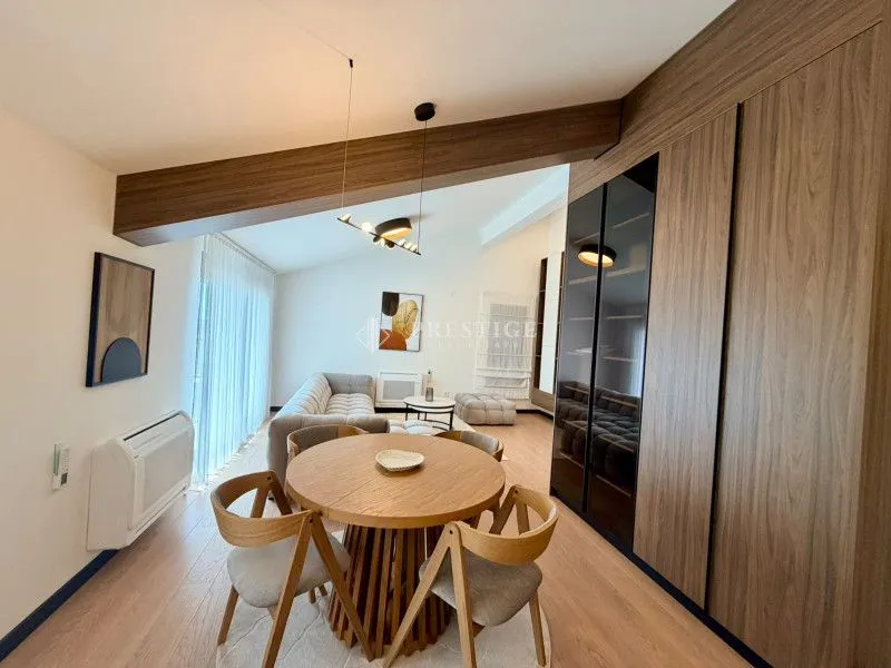 Modern living room with a dining area and wooden furniture.