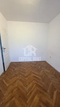 Prazna soba sa drvenim parketom i belim zidovima. - image 8