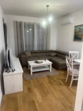 Living room with a sectional sofa, coffee table, and dining area. - image 2