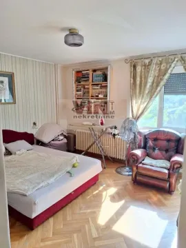 Furnished bedroom with a double bed, an armchair, and a window. - image 5