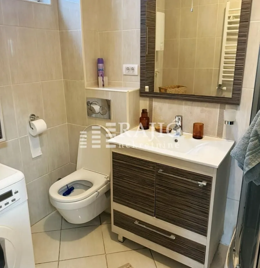 Equipped bathroom with a sink, toilet, and mirror.