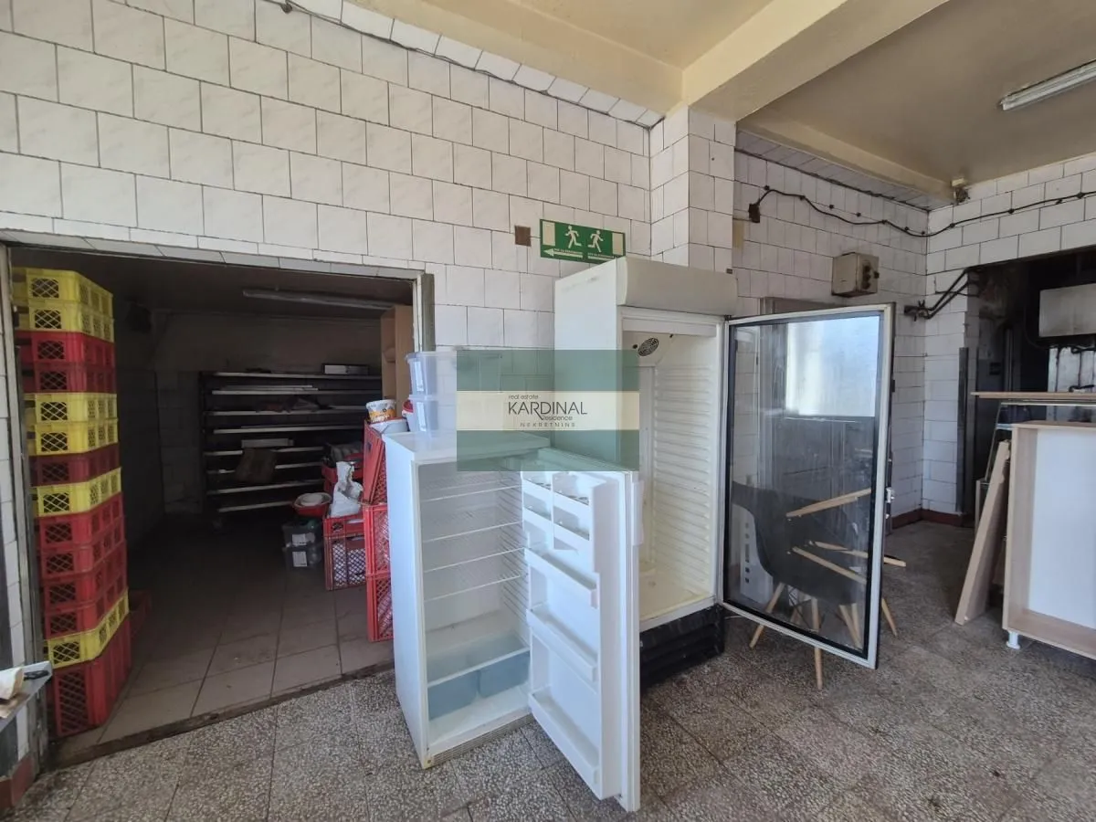 Commercial kitchen with refrigerators and tiled walls.