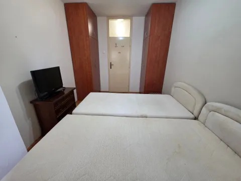Furnished bedroom with two beds, wardrobes and a TV. - image 13