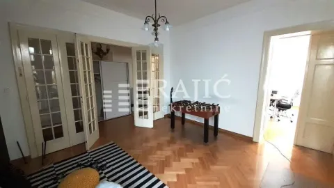 Spacious living room with wooden flooring and double doors. - image 9