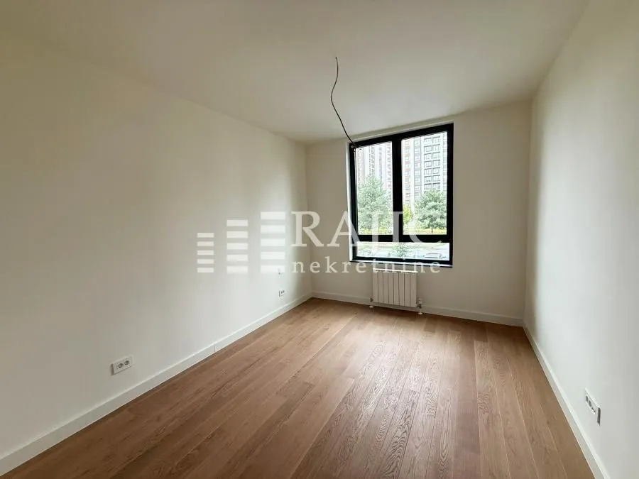 Empty room with wooden flooring and a window.