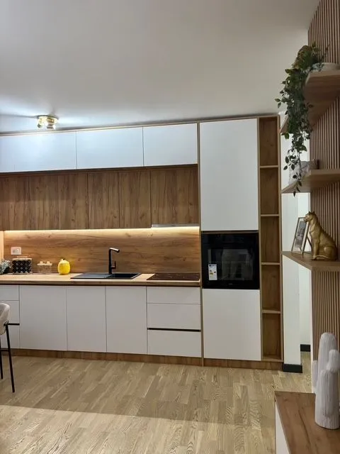 Moderna kuhinja sa bijelim i drvenim elementima.