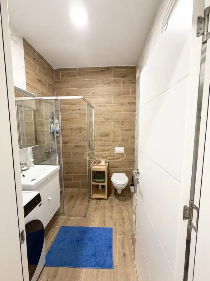 Moderno kupatilo sa tuš kabinom, umivaonikom i wc šoljom.