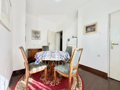 Dining area with a table, four chairs, and a refrigerator in the background. - image 11
