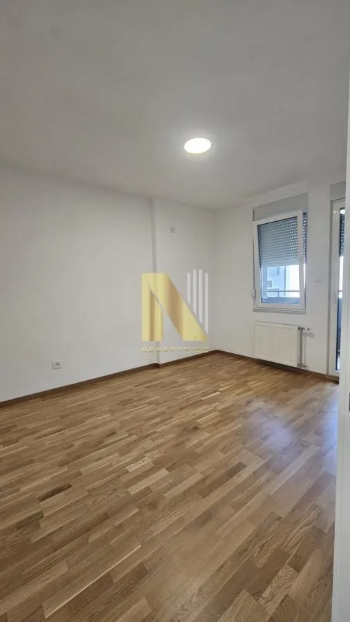 Empty room with hardwood flooring and white walls.