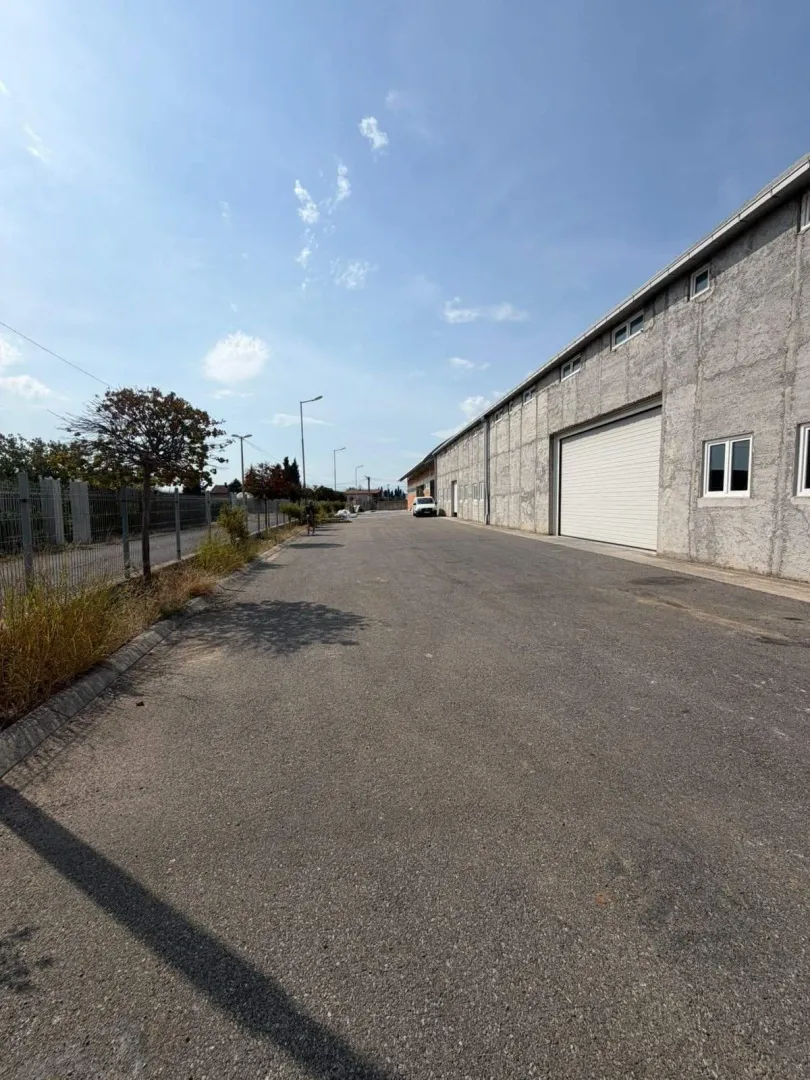 Asphalted yard and access road next to an industrial building.