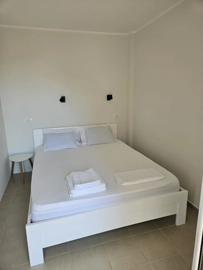 Bedroom with a large double bed and white linens.